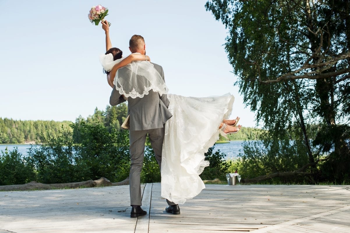 en person som bär en person i en bröllopsklänning