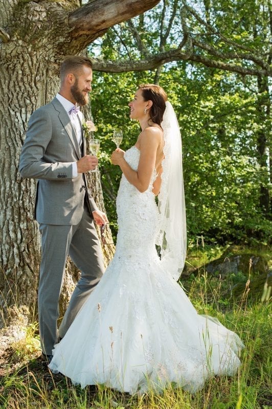 en person och person i bröllopskläder som håller i vinglas