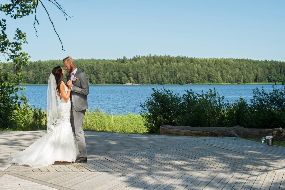 Ett brudpar som dansar vid vattnet